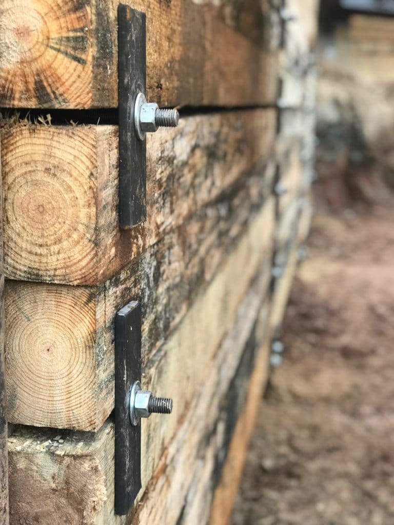 an up close photo of wood lagging attached to the front face of the front flange on a soldier pile wall